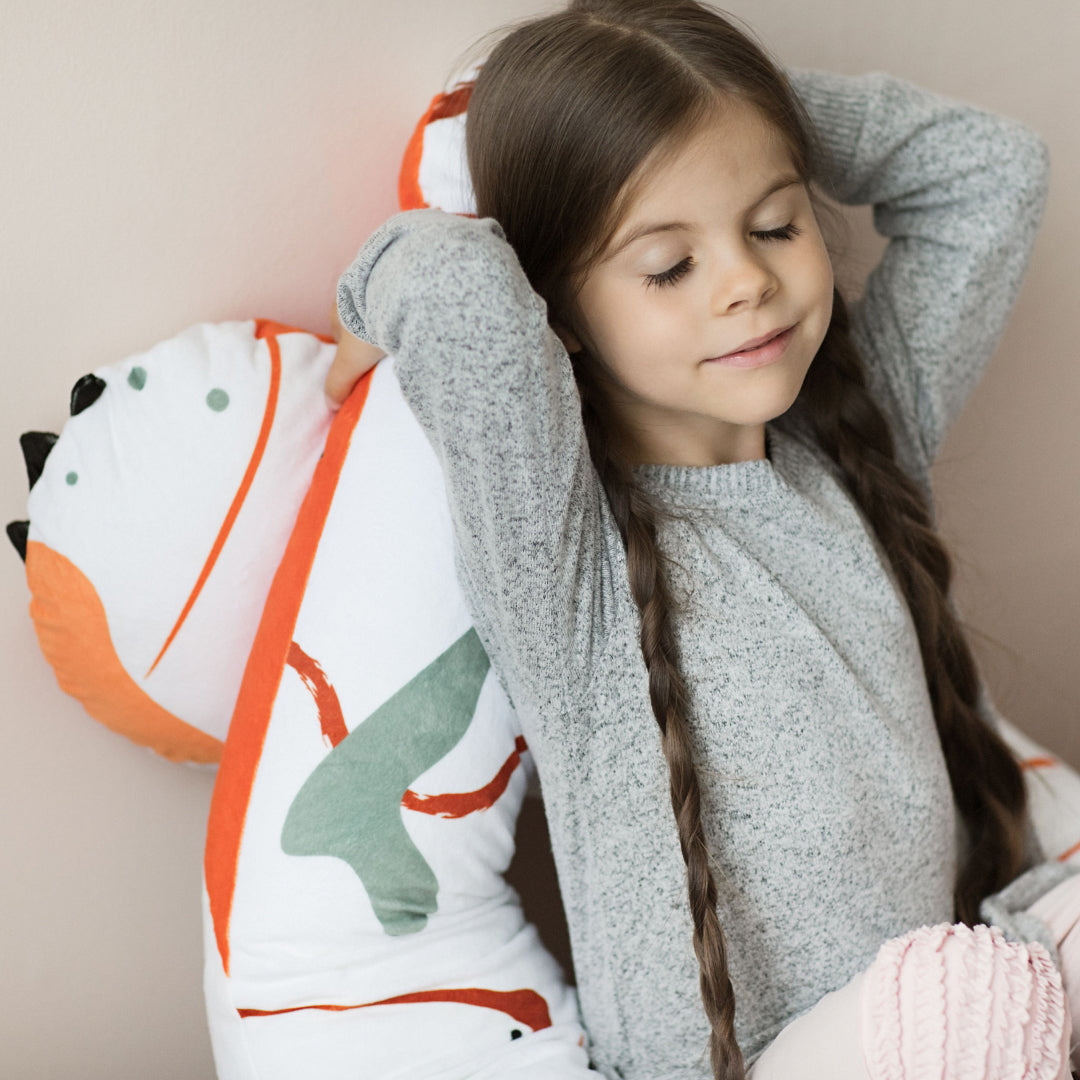 Meisje ligt ontspannen op een vos u-vormig kussen, lekker comfy en ideaal voor een dutje.