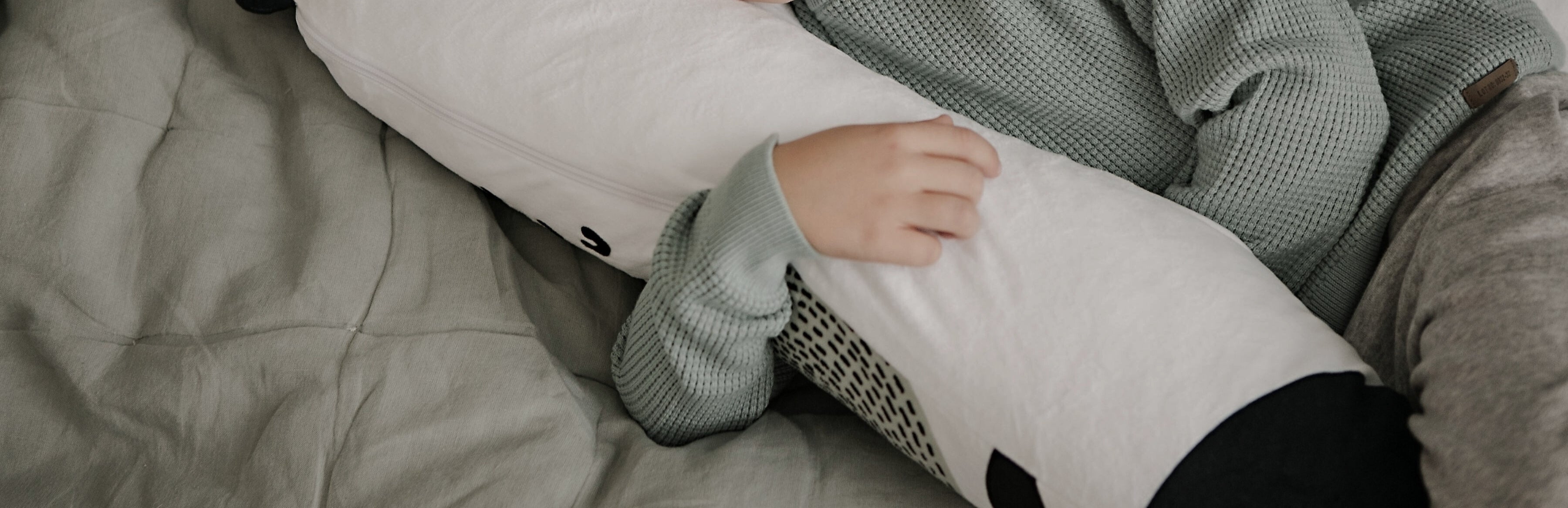 Jongen ligt comfortabel op een u-vormig kinderkussen – rust en slaap voor kinderen